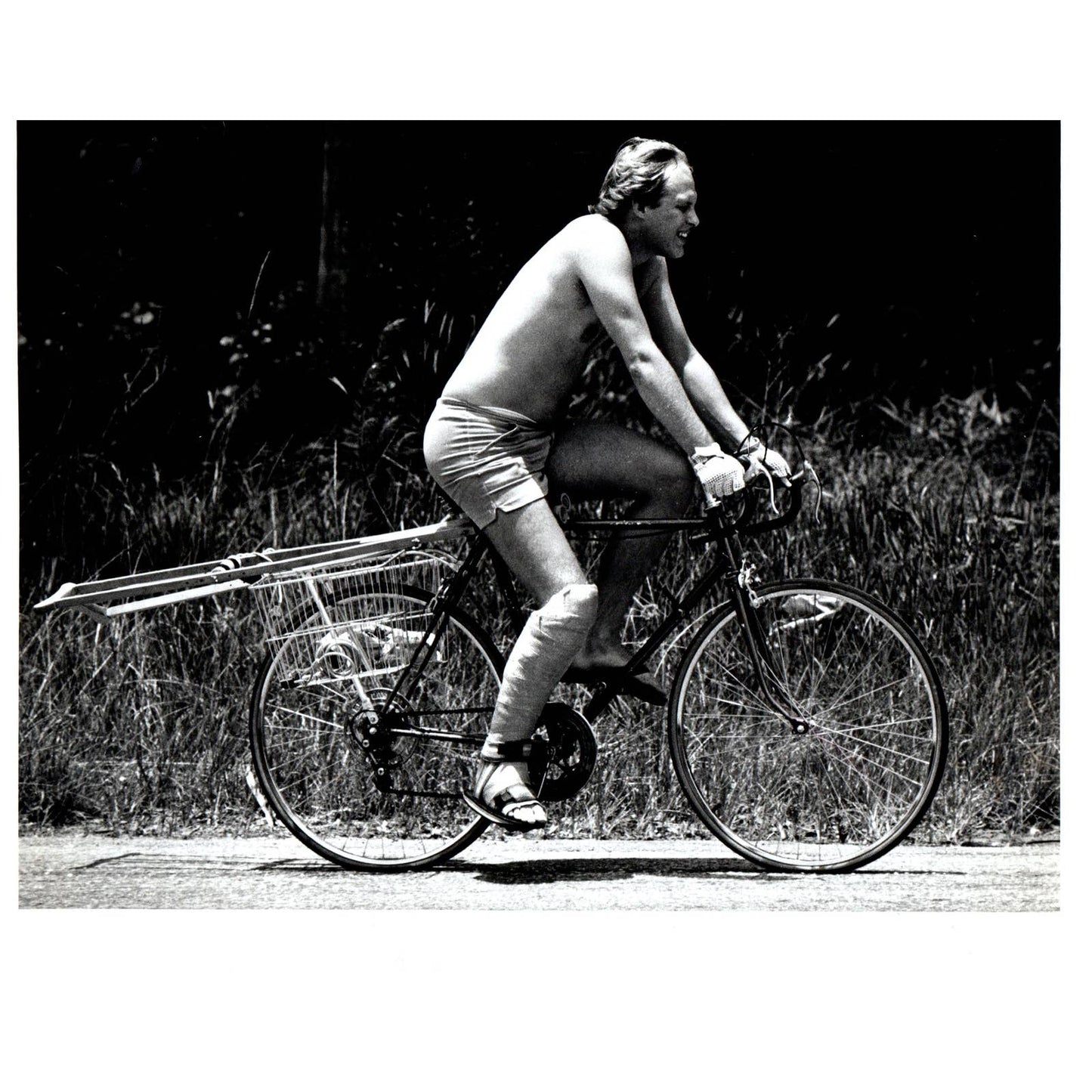 1982 Press Photo Shirtless Man Short Shorts Riding Bike on Crutches 8x10" AD3